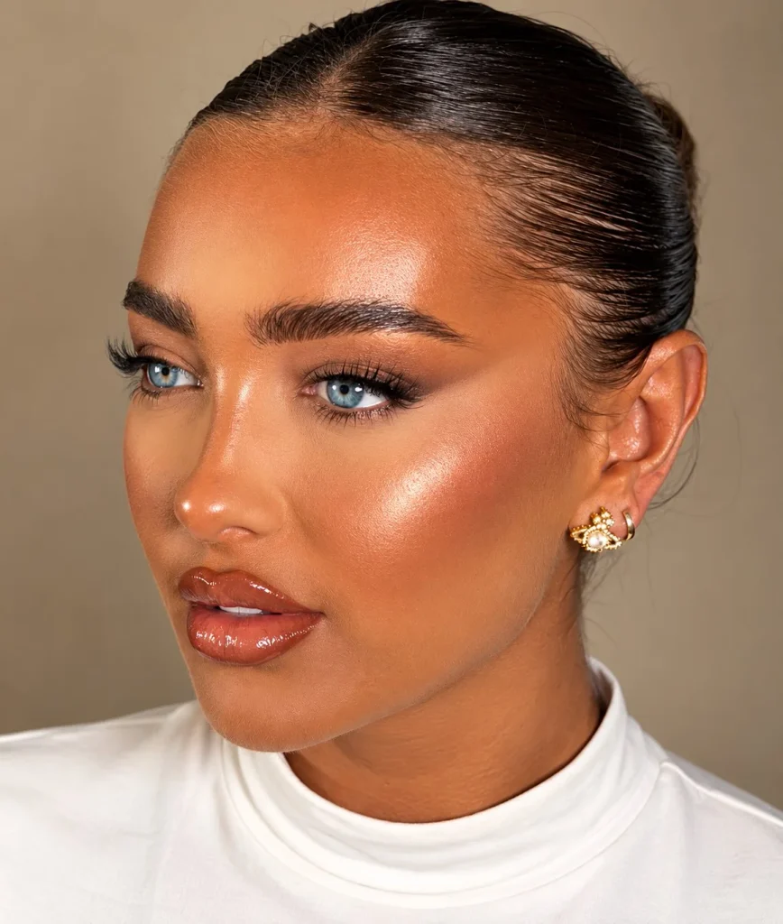 Woman wearing warm cinnamon lipstick with subtle red-orange and brown tones on brown skin