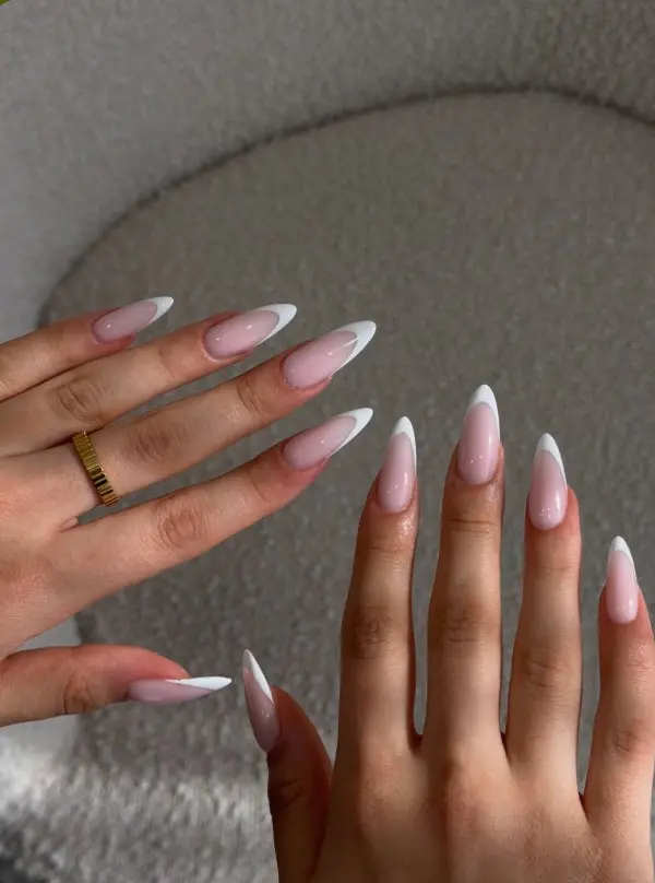 Classic French tip acrylic nails with a sheer nude-pink base and crisp white tips.