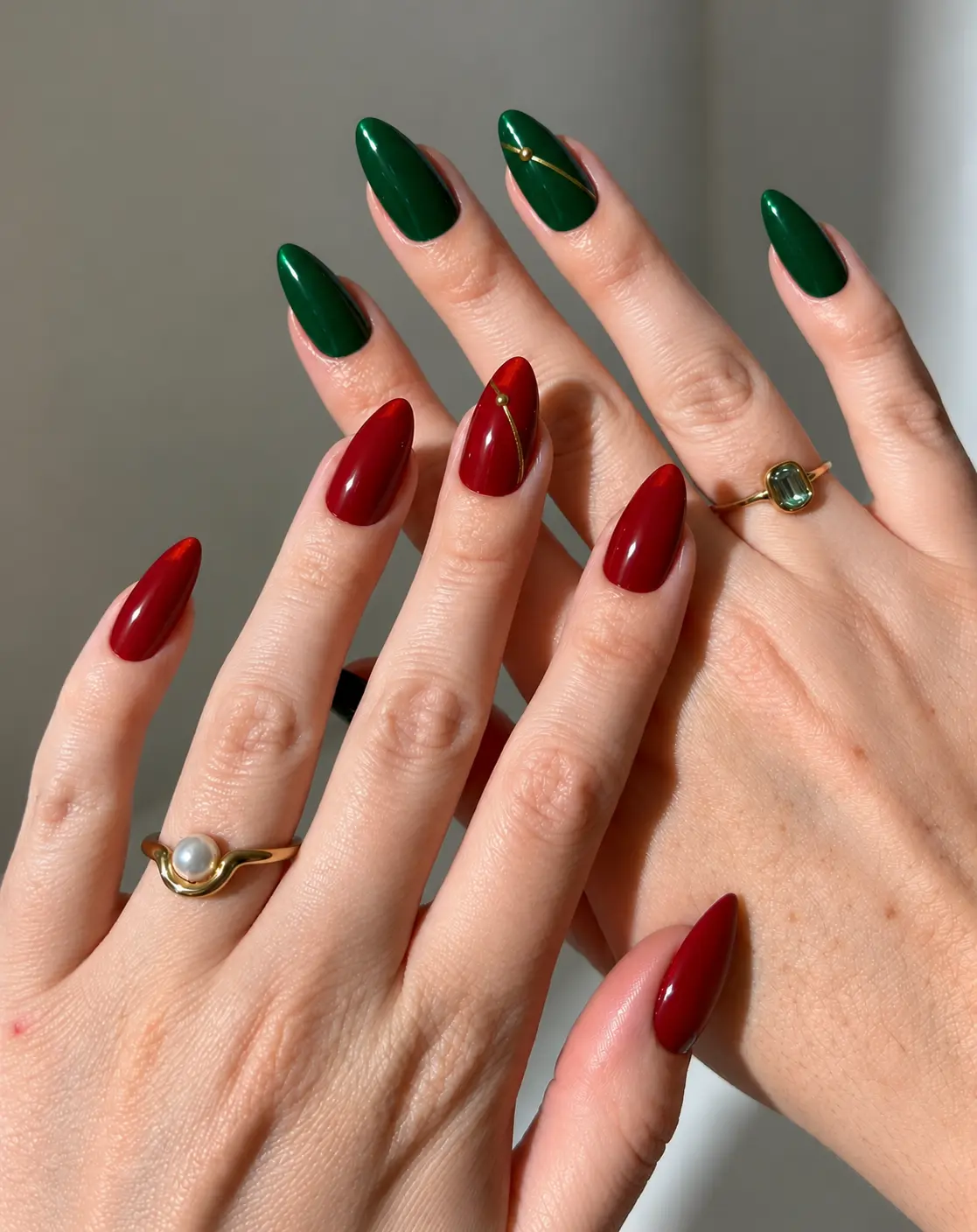 Red and green Christmas nails with tiny gold lines and dots on alternating cherry-red and deep-green polish