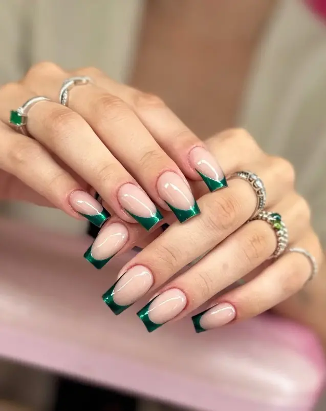 Dark green chrome French tip nails with reflective metallic green tips over a sheer neutral base
