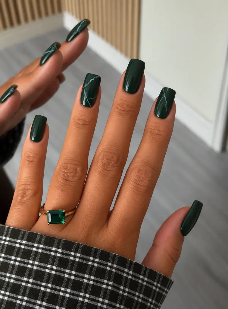 Dark green marble Christmas nails with delicate white veins and a glossy finish