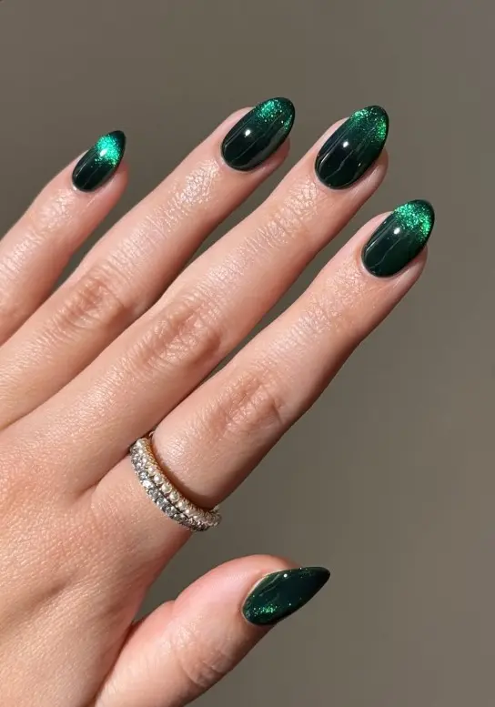 Dark emerald green velvet Christmas nails with a magnetic cat-eye finish and shifting light-catching shimmer