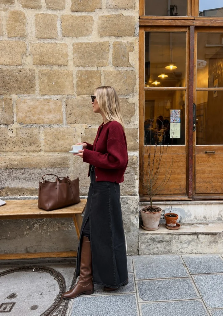 Dark red cardigan with a black denim maxi skirt and tall brown riding boots