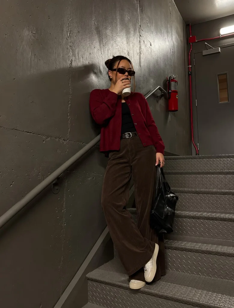 Dark red cardigan paired with chocolate brown corduroy trousers and cream leather sneakers