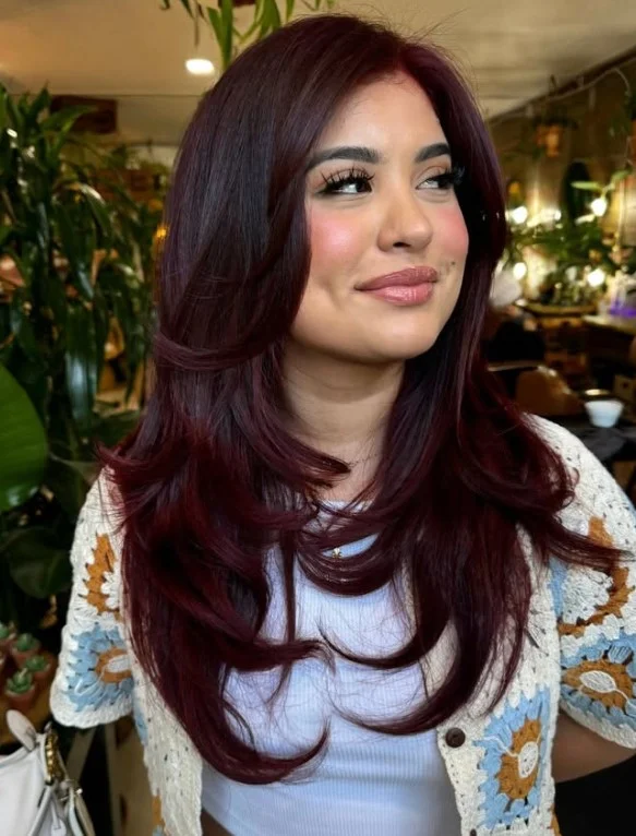 Deep cherry red hair with rich dark red tones on olive skin