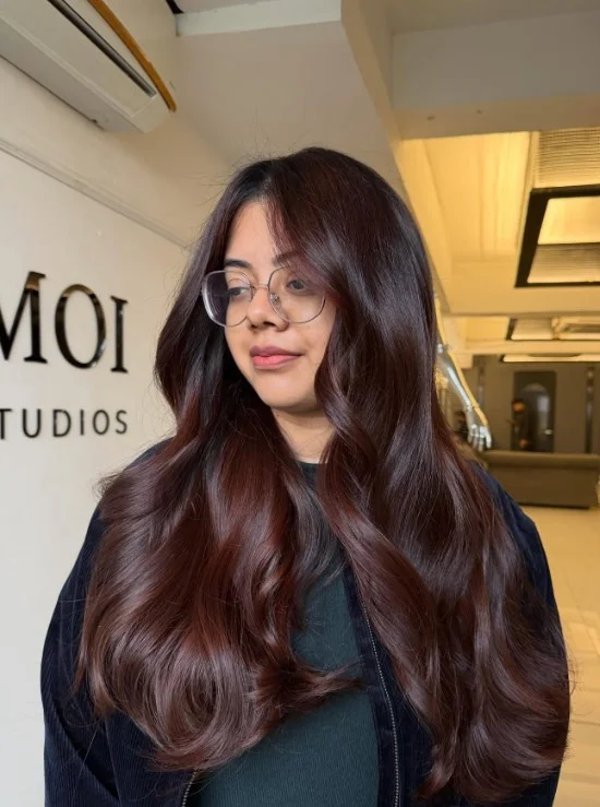 Deep mahogany brown hair with subtle red-violet undertones on olive skin