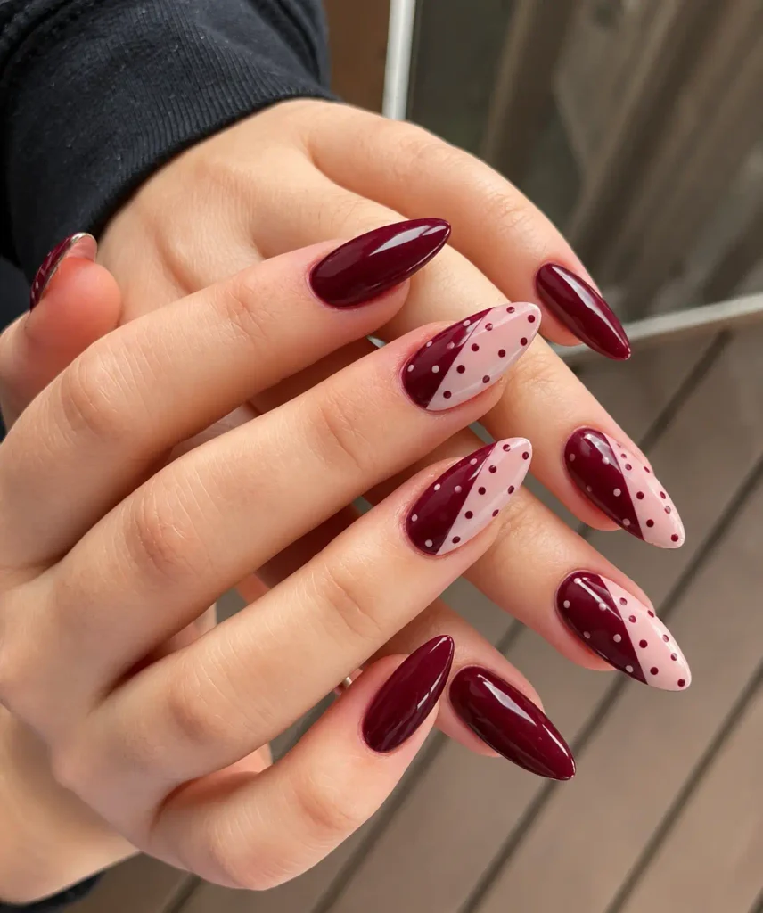 Burgundy and pink nails with diagonal color blocks and contrasting polka dots