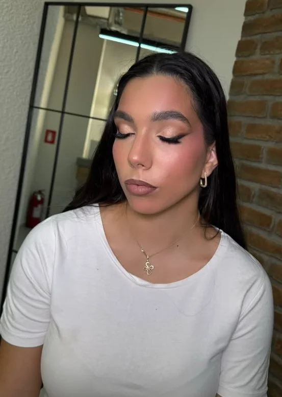 Woman wearing muted dusty rose lipstick with soft pink tones on brown skin