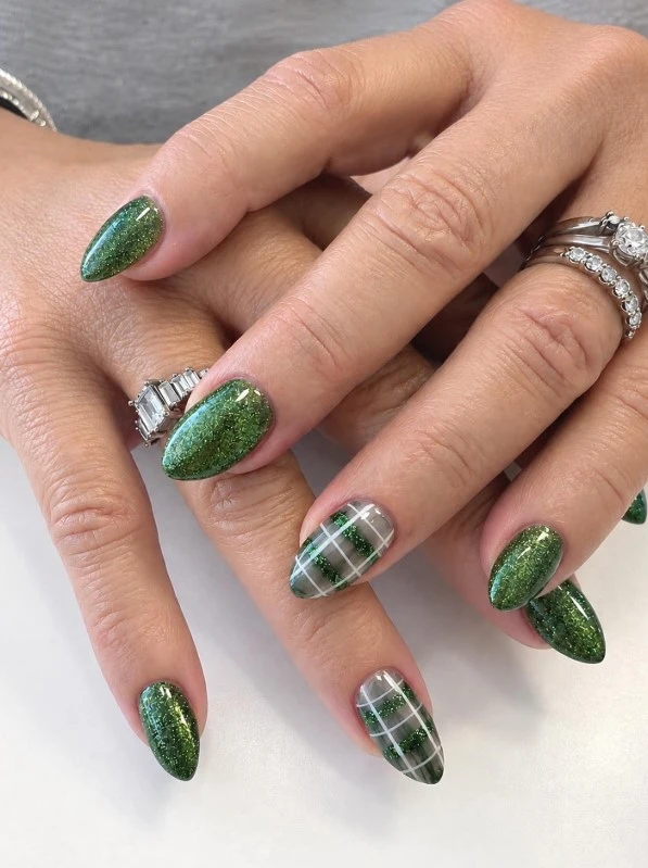 Green glitter Christmas manicure with plaid accent nails featuring thin intersecting white lines on a sheer gray base