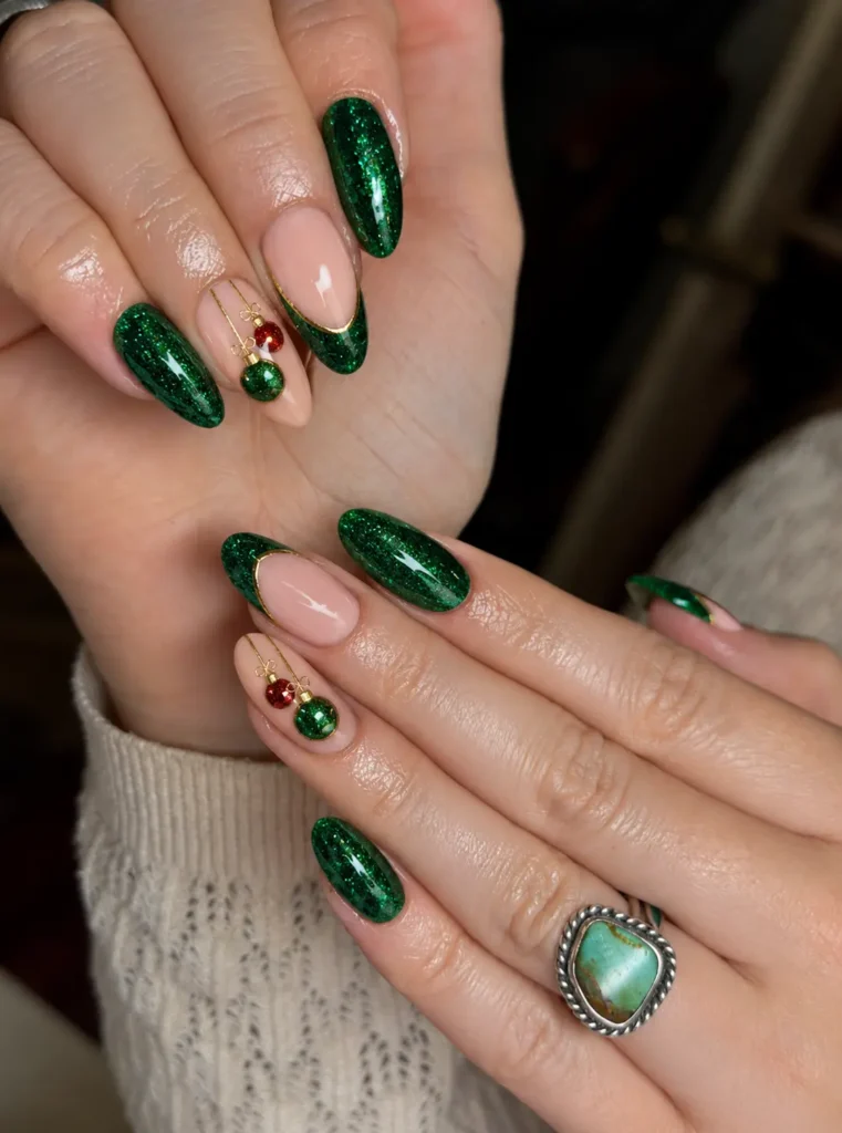 Green glitter Christmas nails with small hanging Christmas baubles in red, gold, or white on an accent nail