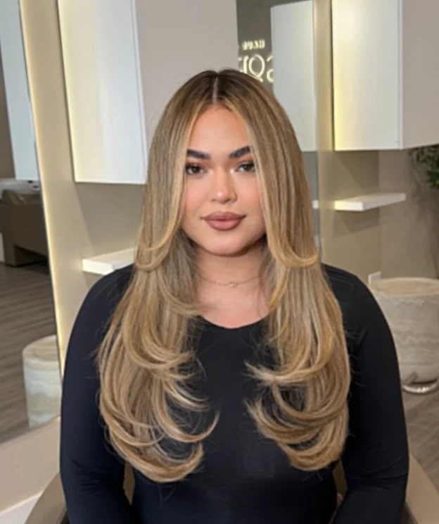 Honey blonde hair with dark roots and softly blended lighter lengths