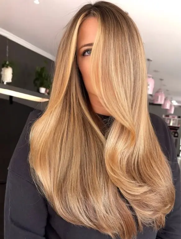 Light brown hair with honey blonde highlights adding golden warmth and brightness around the face