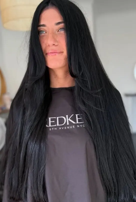 Inky black hair with a deep even finish creating dramatic contrast against pale skin and blue eyes