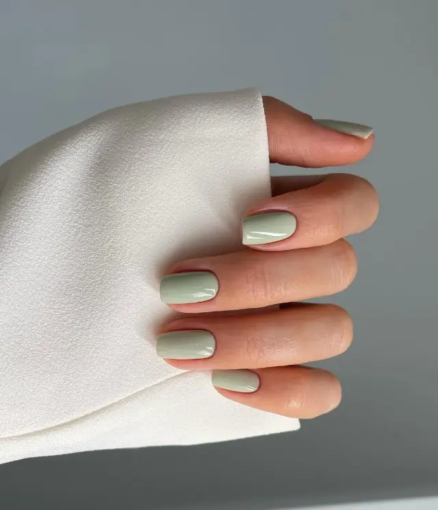 Glossy matcha green acrylic nails in a muted earthy green shade.