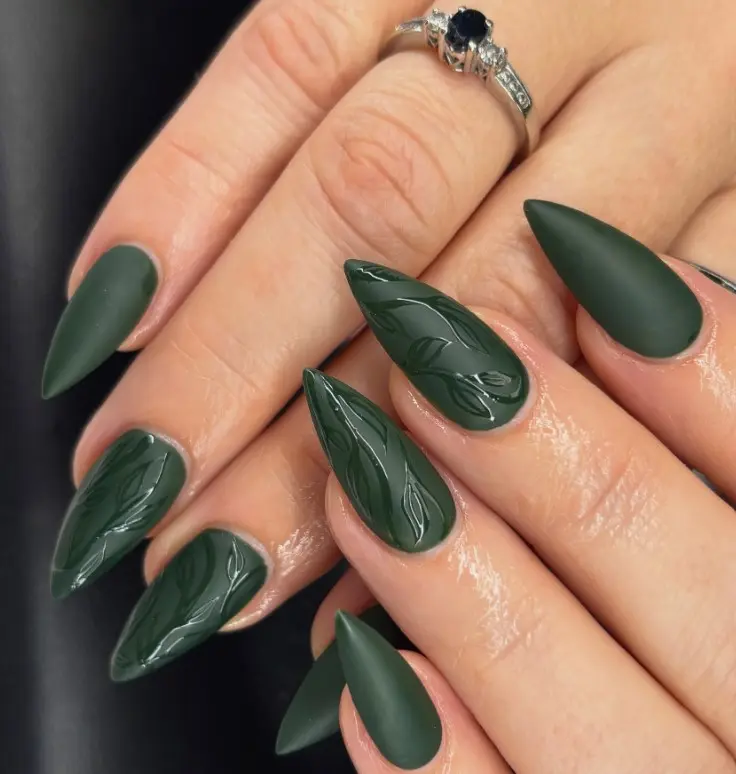 Matte dark green nails with glossy green stripes, curved lines, or leaf patterns creating a subtle texture contrast