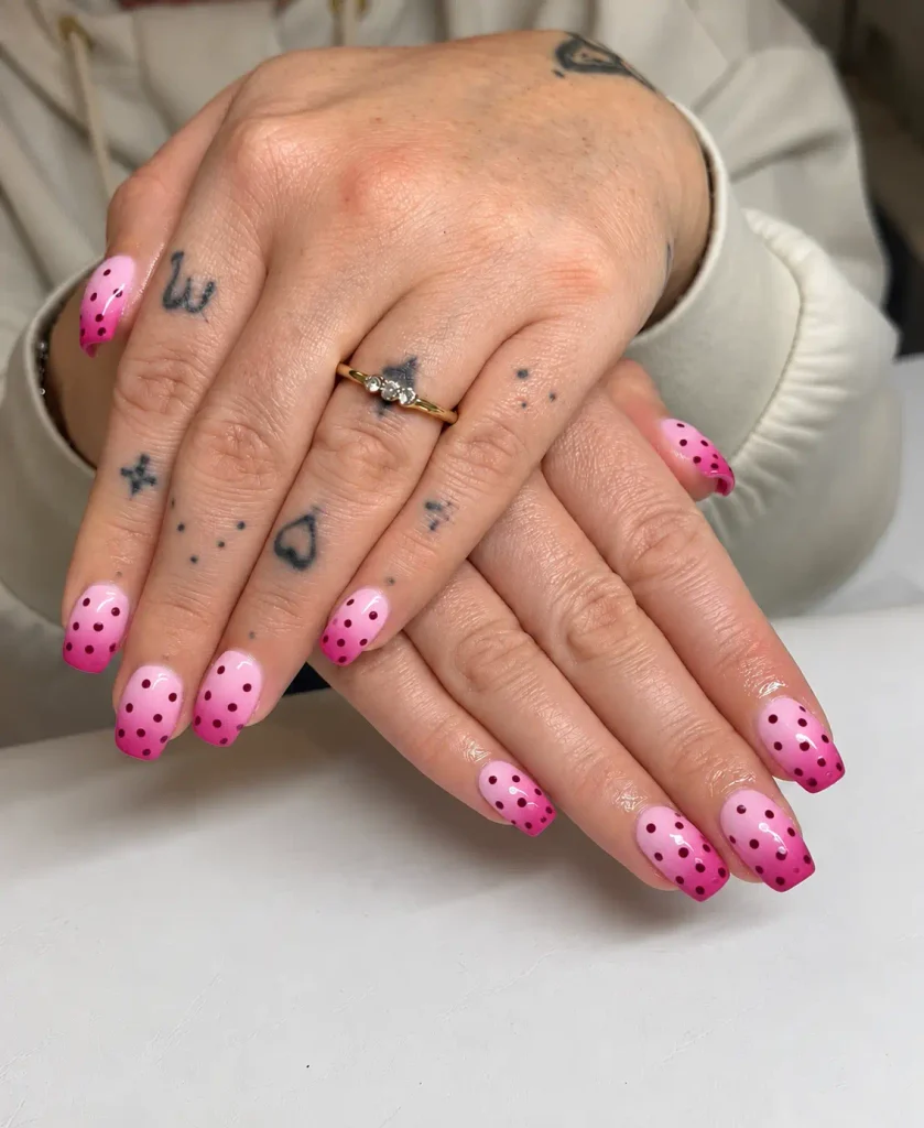 Pink ombré nails decorated with burgundy polka dots