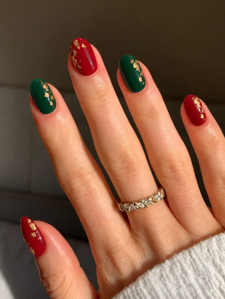 Red and emerald green Christmas nails with scattered irregular gold foil flakes