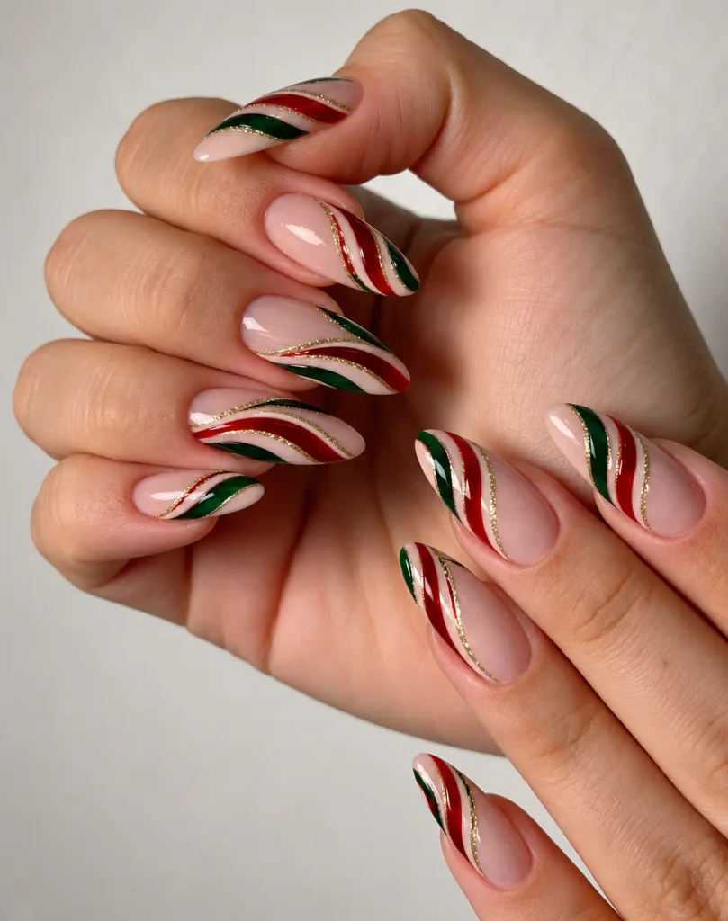 Red and green candy cane Christmas nails with curved stripes and thin gold accent lines