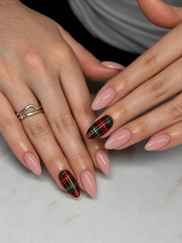 Red and forest-green Christmas tartan nails with thin intersecting gold stripes in a plaid pattern