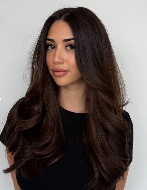Rich chocolate brown hair with soft waves on olive skin