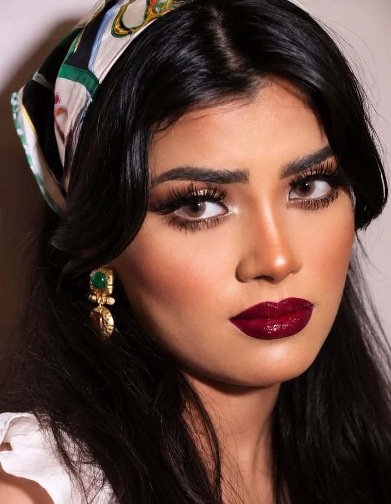 Woman wearing deep wine lipstick with rich red and purple tones on brown skin
