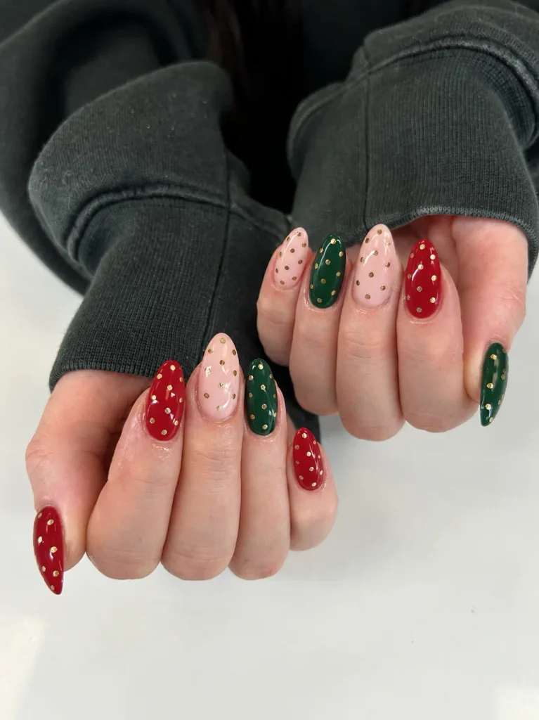 Short red and green Christmas nails decorated with small gold polka dots