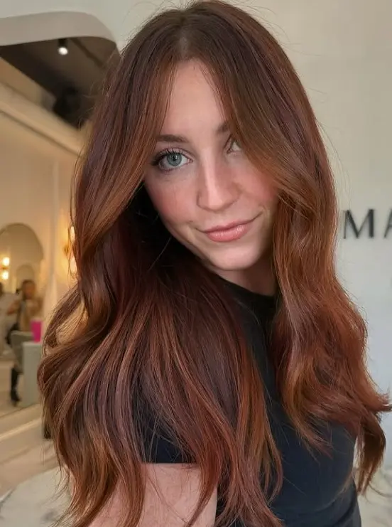Soft auburn hair blending warm red and brown tones for a natural-looking redhead color