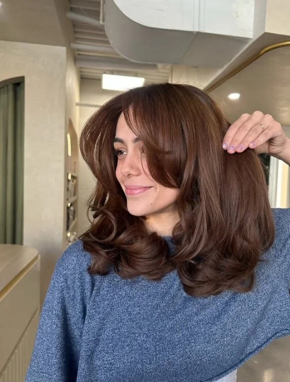 Soft chestnut brown hair with warm red undertones on olive skin