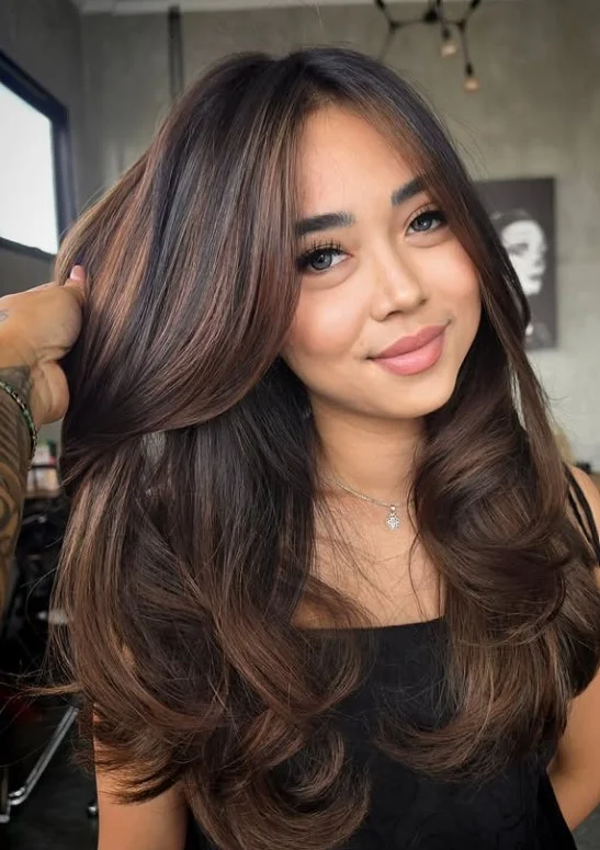 Warm caramel balayage blended through brunette hair on olive skin